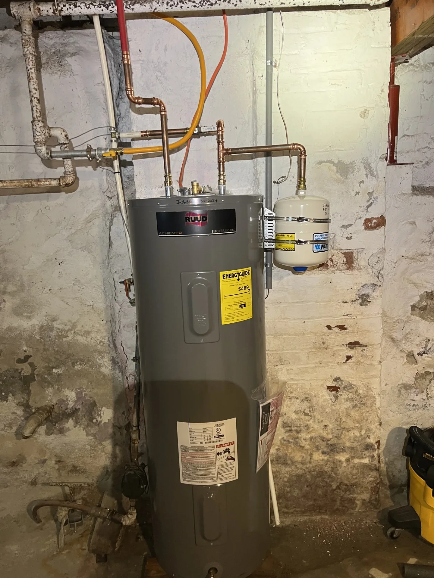 Ruud electric water heater with copper plumbing and Watts expansion tank installed in basement